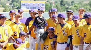 A group of young men in yellow and purple baseball uniforms.
